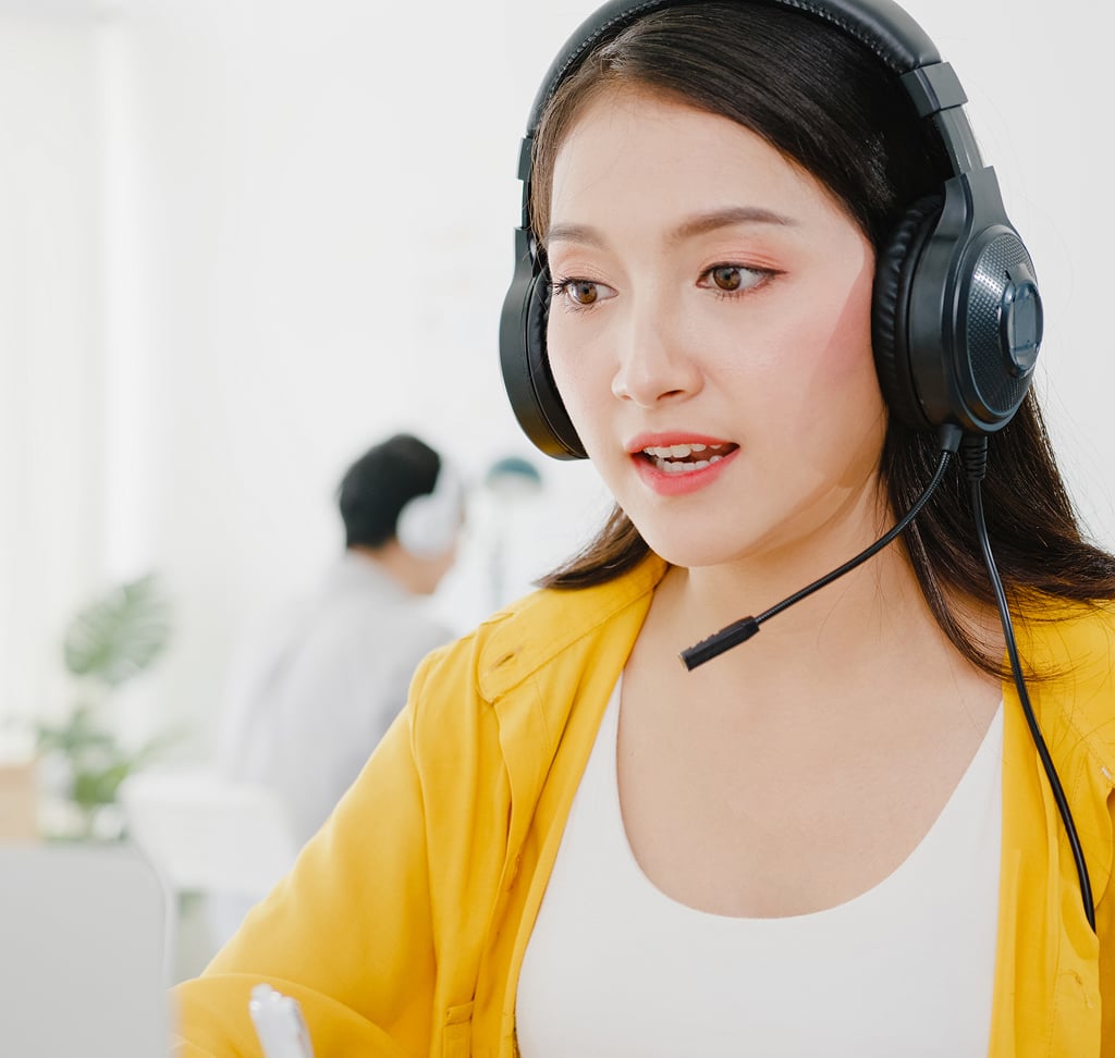 Asian businesswoman on a video call with colleagues while working on a laptop