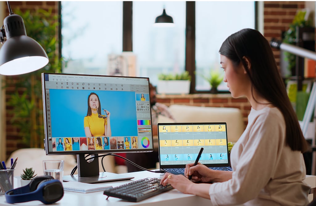 Asian graphic designer using editing software for photo retouching — offshore creative role