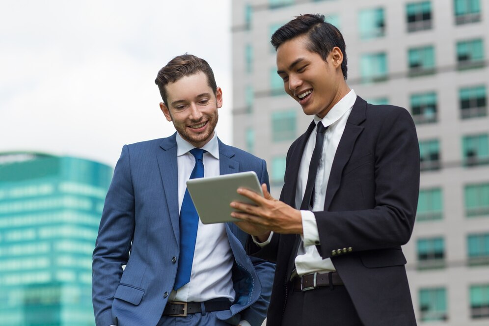 Cultural Compatibility and Business Alignment closeup smiling coworkers using tablet outdoors 1262 3493