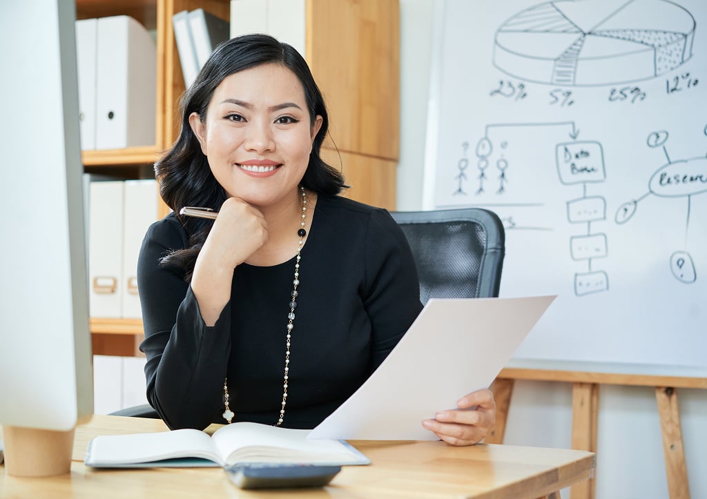 Smiling businesswoman working confidently at her office desk