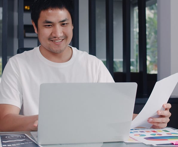 Young Asian man stressed while recording budget and financial documents on a laptop