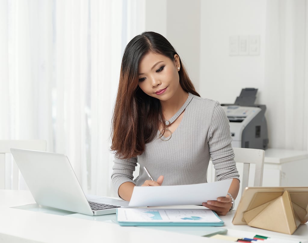 Young elegant woman working professionally at her office workstation