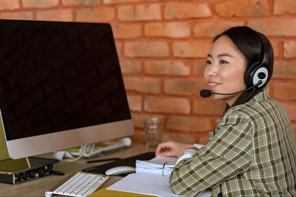 Offshore customer service agent wearing a headset at a desktop computer