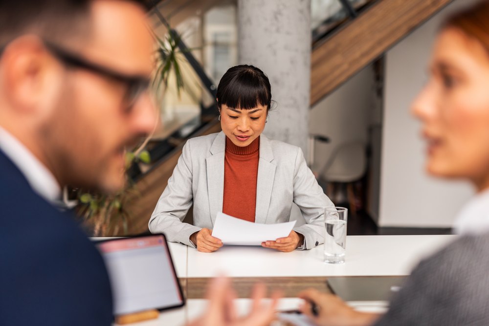 Hiring manager reviewing a candidate CV across a table during an interview, illustrating how to vet a Philippines outsourcing partner